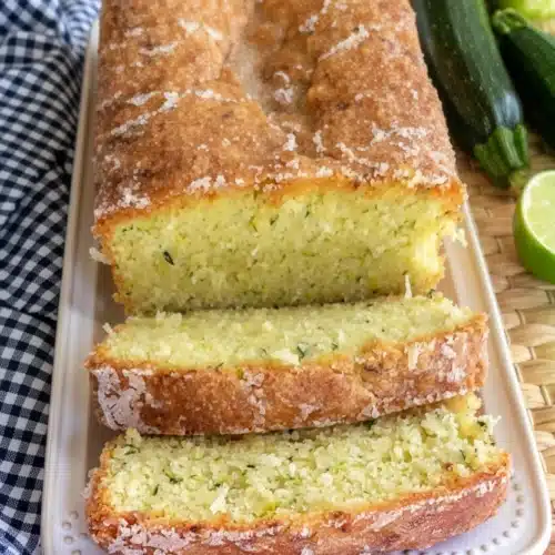 Coconut Lime Zucchini Bread: A Delightful Treat 2 Moist coconut lime zucchini bread with glaze, sliced, on white plate with zucchini and lime