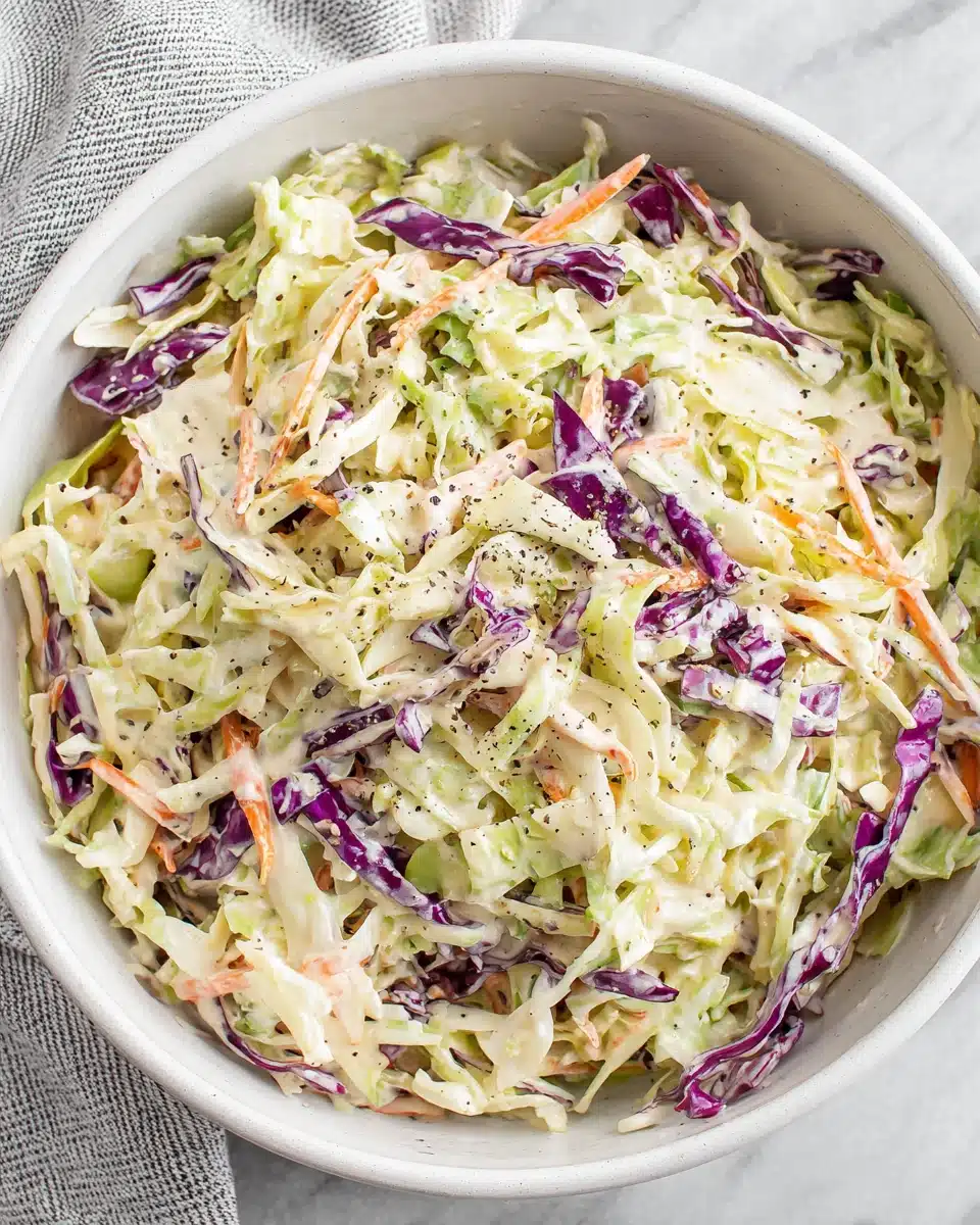 Creamy coleslaw with shredded cabbage and carrots in a white bowl