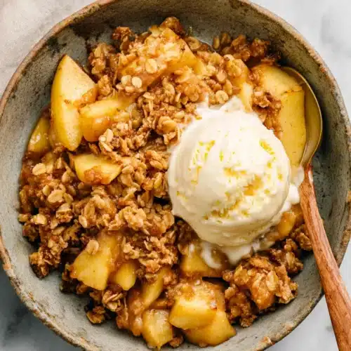 Apple crisp recipe with vanilla ice cream in a ceramic bowl