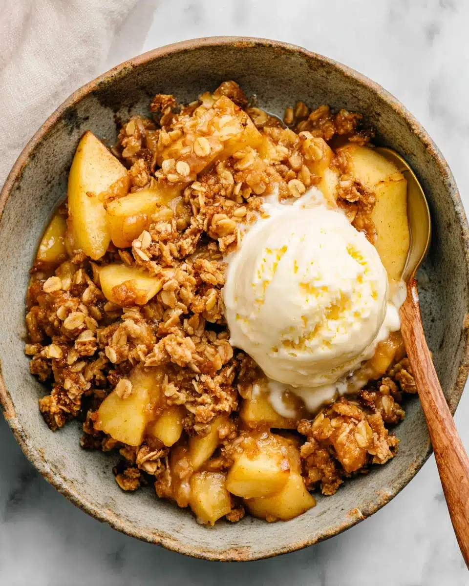 Apple crisp recipe with vanilla ice cream in a ceramic bowl
