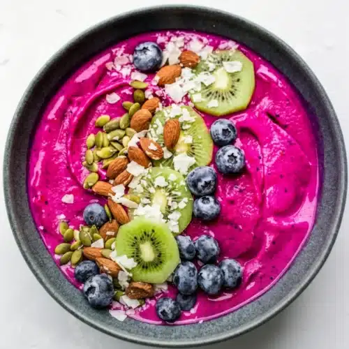 Delicious Dragon Fruit Smoothie Bowl: A Tropical Delight 2 Vibrant dragon fruit smoothie bowl with kiwi, blueberries, and nuts