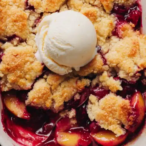 Easy old fashioned peach cobbler with golden topping and vanilla ice cream