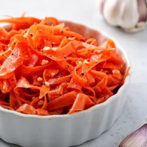 Fermented Carrot Salad: A Tangy Delight for Your Dinner Table 2 Fermented carrot salad in white bowl with fork, crisp tangy side dish