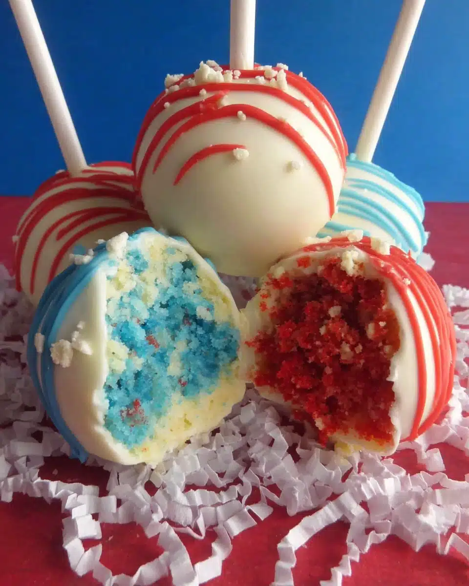 Fourth of July cake pops with red, white, and blue drizzles and colorful interiors