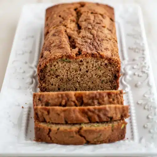 Gluten free dairy free zucchini bread loaf sliced on white platter