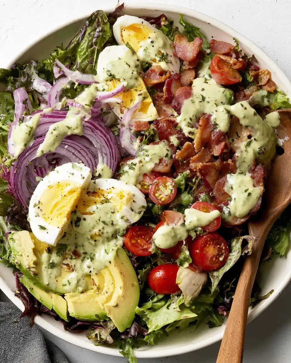Green goddess cobb salad with creamy dressing, bacon, avocado, and eggs.
