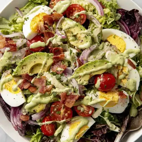 Green goddess cobb salad with creamy dressing, avocado, bacon, and eggs.