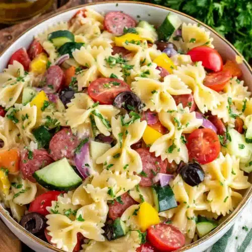Colorful Italian pasta salad with bow tie pasta, tomatoes, cucumbers, and olives