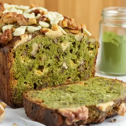 Moist matcha banana bread with white chocolate chips and walnuts, sliced and ready to serve.