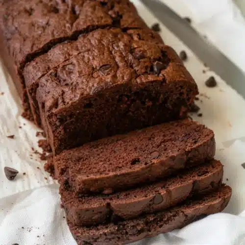 One Bowl Chocolate Zucchini Bread: Indulgent and Simple 2 One bowl chocolate zucchini bread with chocolate chips, sliced and served on a white cloth