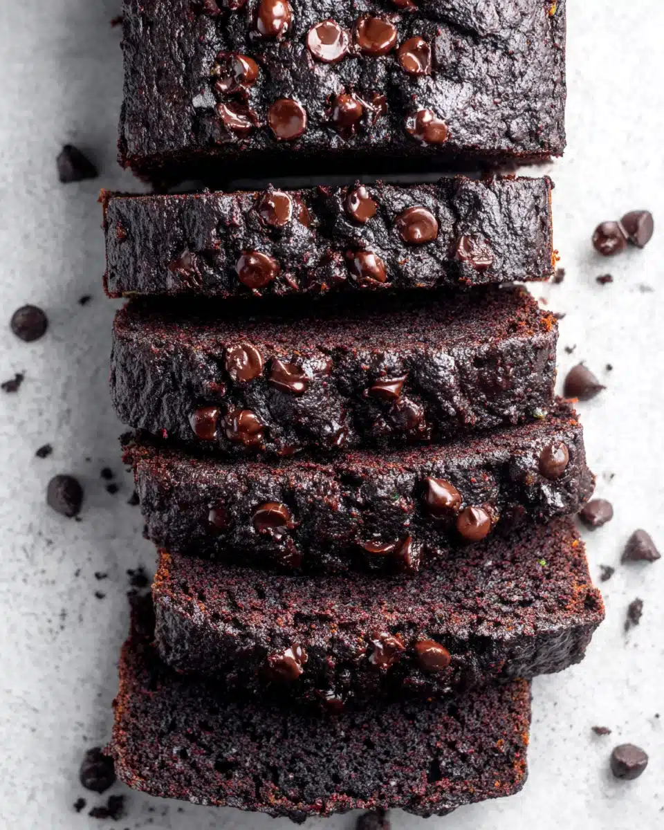 Slices of one bowl gluten free chocolate zucchini bread with chocolate chips on marble
