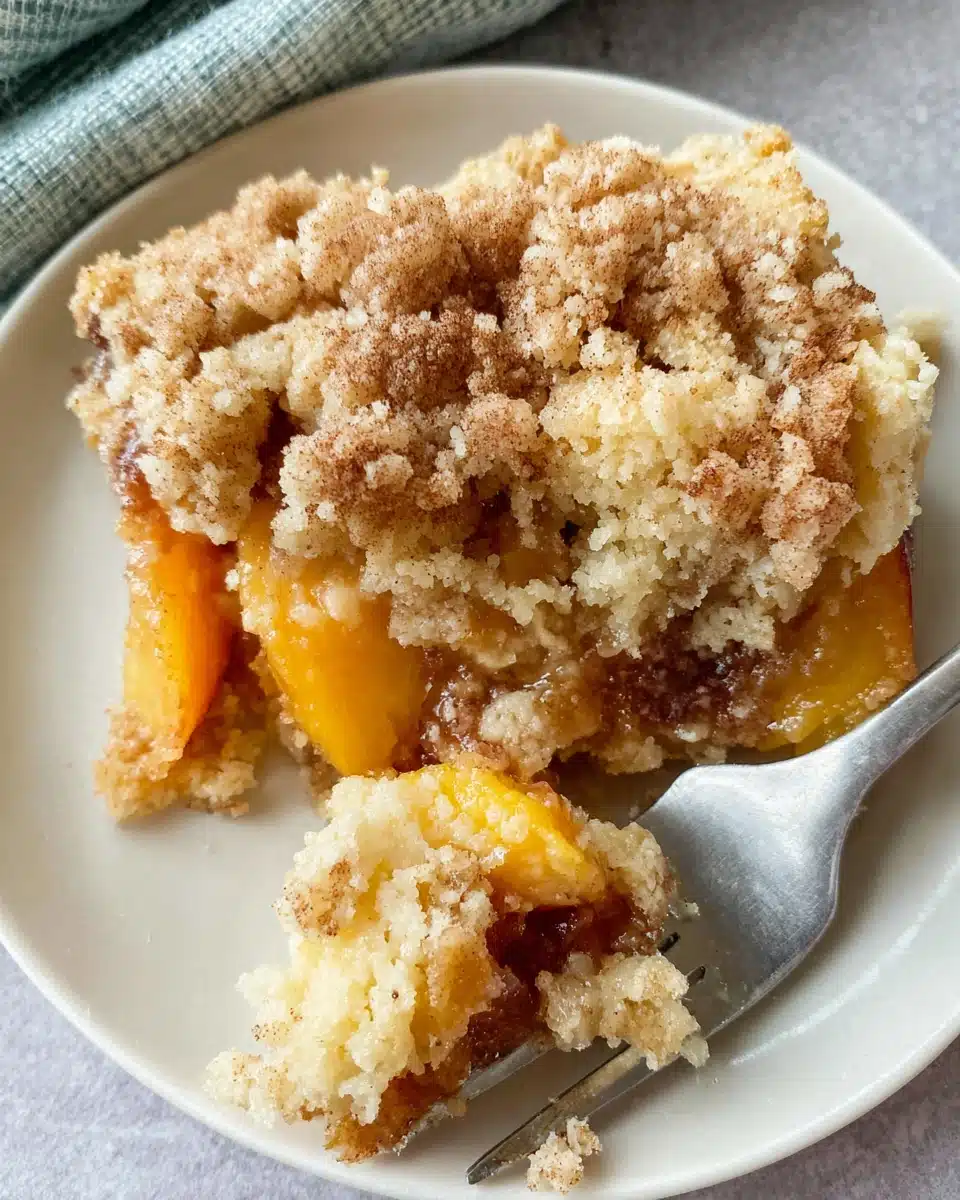 A slice of peach cobbler with frozen peaches and cake mix on a white plate