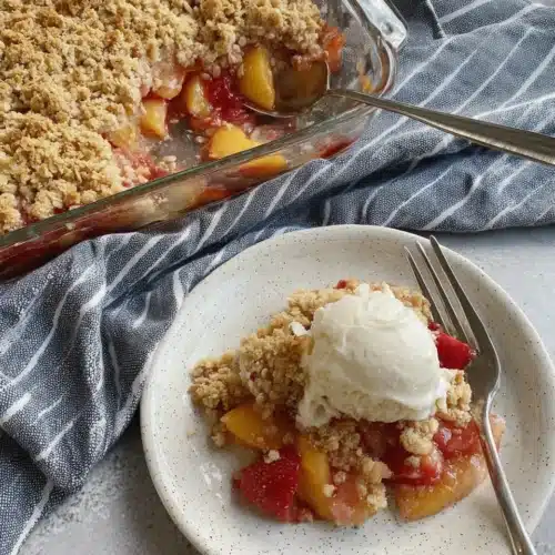 Easy Peach Crumble Crisp That Will Delight 1 Peach crumble crisp with vanilla ice cream on a plate, golden crumble topping, juicy fruit filling.