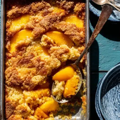 Peach dump cake is the low effort dessert with golden crispy topping and juicy peaches