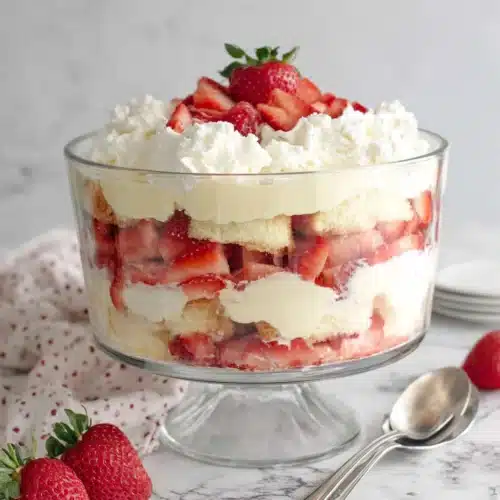 Layered punch bowl cake with strawberries and cream in a glass bowl