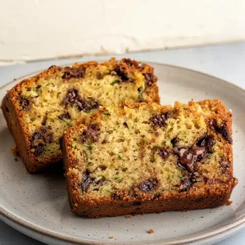 Tender zucchini bread with melty chocolate, sliced and served on a marble board