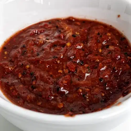 Wingstop Atomic Sauce: Fiery and Irresistibly Good 2 Wingstop atomic sauce in a white bowl, spicy red with visible spices