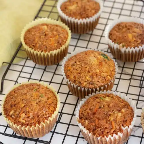 Delicious Zucchini Carrot Muffins You'll Love 2 Zucchini carrot muffins cooling on a wire rack, golden-brown and moist