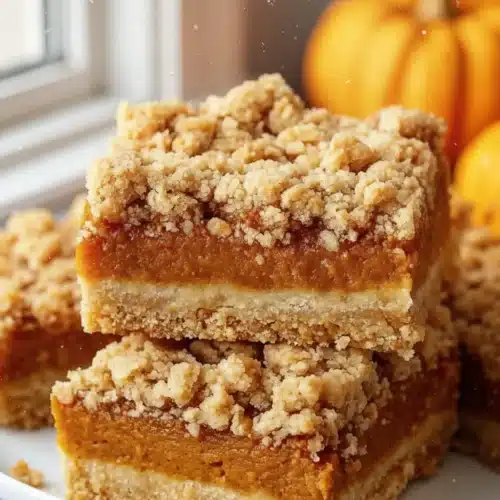 The Best Pumpkin Desserts: Irresistibly Delicious Treats 2 Stacked pumpkin crumble bars with oat topping and pumpkins in background, best pumpkin desserts