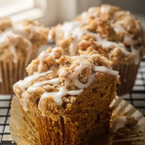Country pumpkin muffins with streusel topping and drizzle on cooling rack