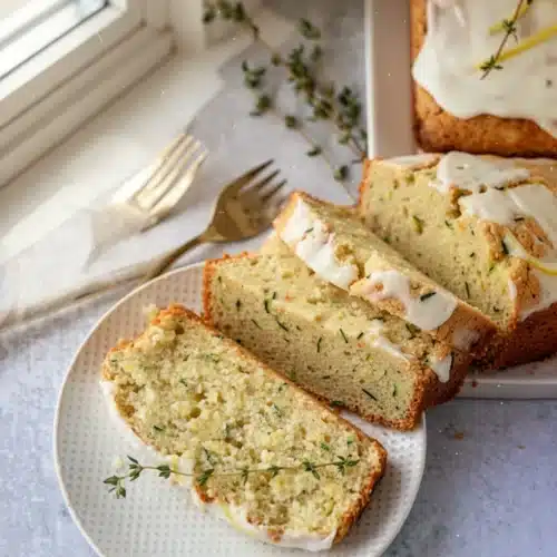 Gluten Free Lemon Zucchini Bread: A Refreshing Delight 2 Gluten free lemon zucchini bread slice with lemon glaze and thyme garnish