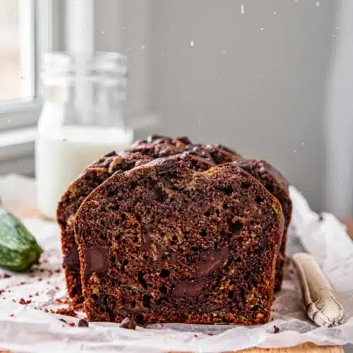 Moist healthy chocolate zucchini bread with chocolate chunks on a wooden board