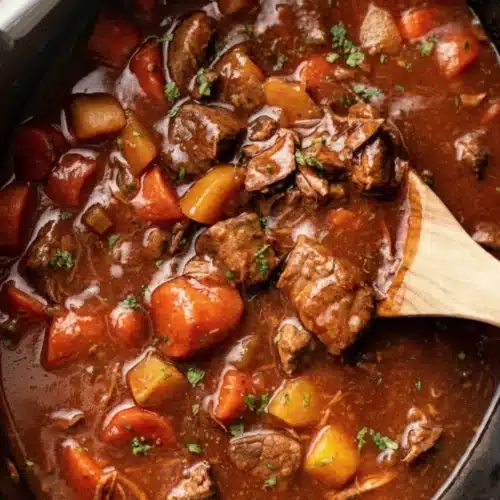 Slow cooker beef stew with tender beef, carrots, and potatoes in a rich broth