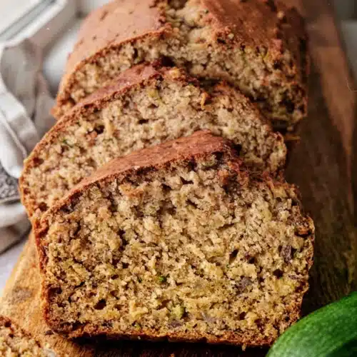 Zucchini Banana Bread: The Perfect Healthy Indulgence 2 Moist zucchini banana bread slices with visible zucchini and nuts on wooden board